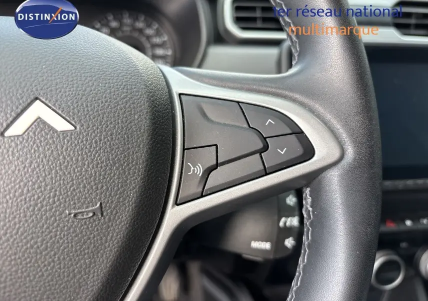 Gros plan sur le volant noir du Dacia Duster 2024, version Journey TCE 150 EDC, avec commandes intégrées côté droit.