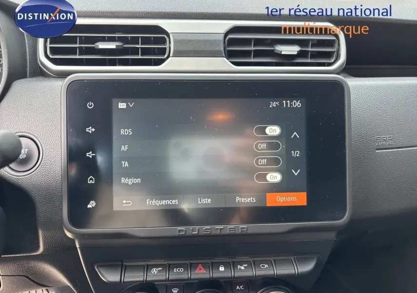 Vue rapprochée de l’écran tactile central du Dacia Duster noir 2024, avec commandes climatisation et boutons fonctionnels visibles.