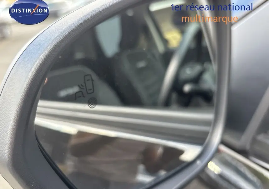 Rétroviseur extérieur gauche du Dacia Duster noir 2024, avec indication d'alerte d'angle mort visible sur le miroir.