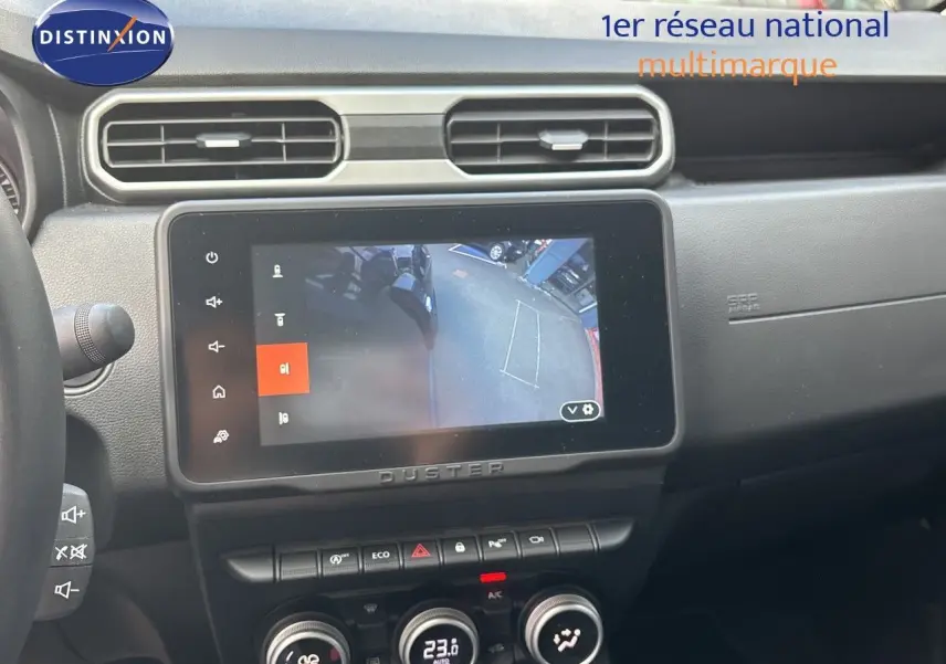 Intérieur du Dacia Duster 2024 noir, vue sur la console centrale avec écran tactile affichant la caméra de recul.