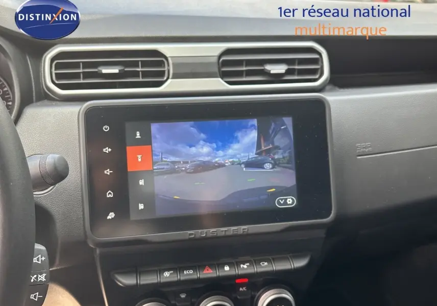 Vue intérieure centrée sur l’écran tactile du tableau de bord du Dacia Duster noir, affichant la caméra de recul.