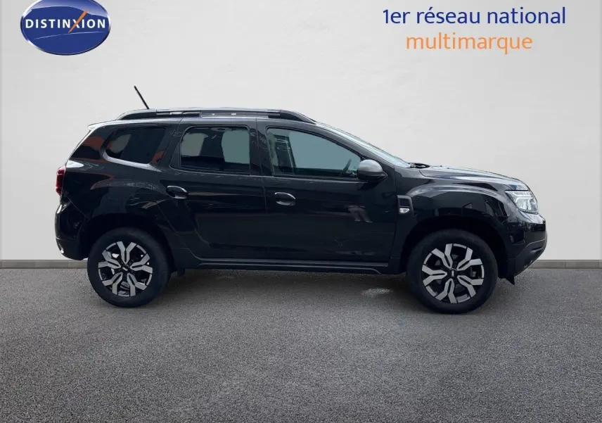 Profil latéral droit du Dacia Duster Journey TCe 150 EDC noir 2024 avec jantes bi-ton et toit équipé de barres de toit.