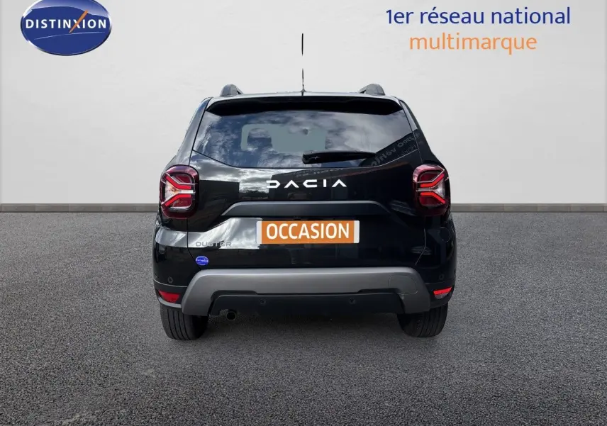 Vue arrière d’un Dacia Duster noir 2024 avec logo et feux arrière LED distinctifs, sur fond neutre.