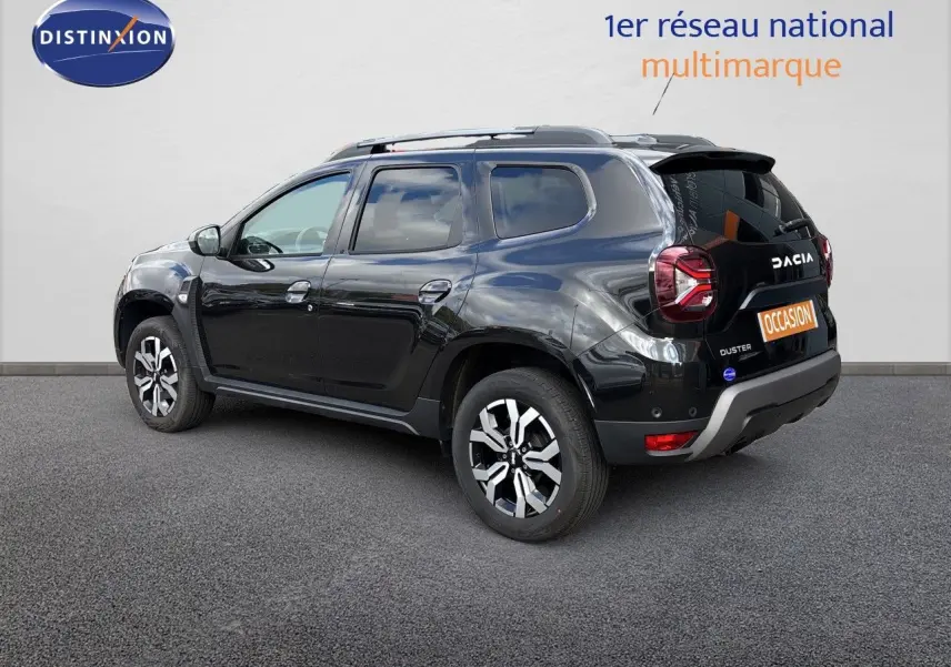 Vue 3/4 arrière droite d'un Dacia Duster noir 2024 avec jantes bicolores et détails chromés sur carrosserie.