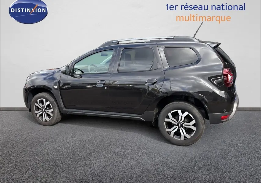 Profil droit du Dacia Duster Journey TCe 150 EDC noir 2024 avec jantes biton et barres de toit visibles.