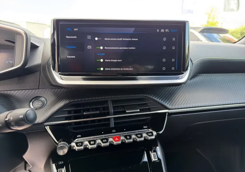 Vue intérieure du tableau de bord du Peugeot 2008 Hybrid 145 e-DCS6 GT 2026 avec écran tactile central et commandes piano noir.