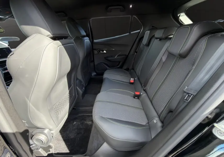 Vue intérieure côté droit sur la banquette arrière noire avec surpiqûres vertes du Peugeot 2008 Hybrid 145 e-DCS6 GT 2026.