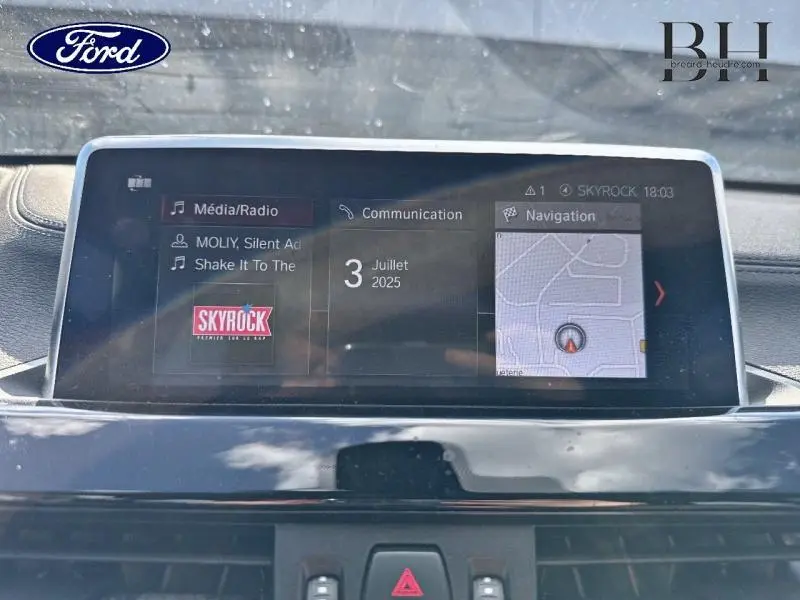Écran central multimédia du BMW X1 xDrive25e 2021 affichant radio Skyrock et navigation.
