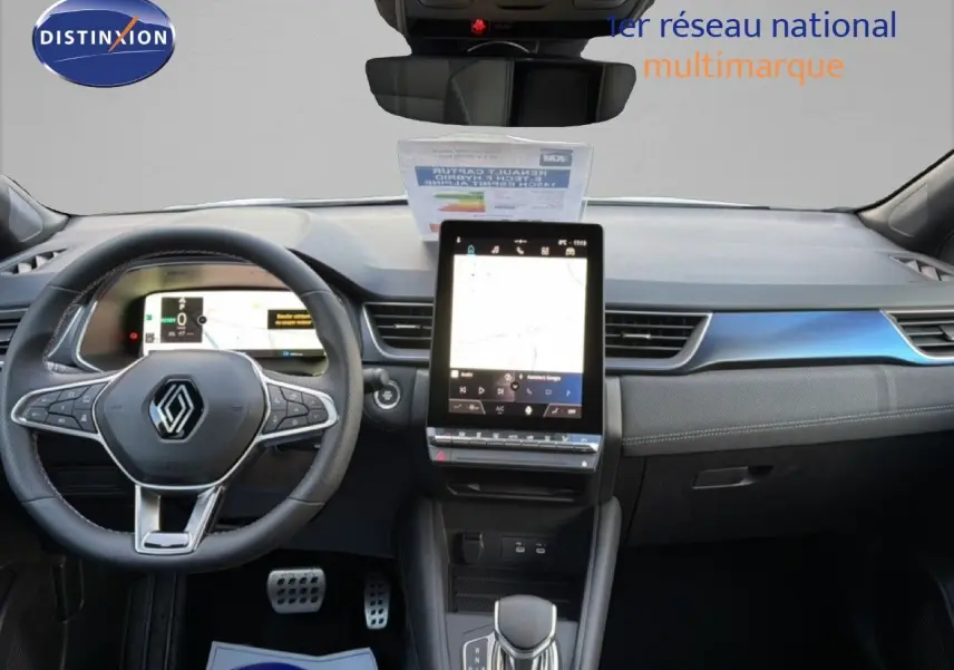 Vue intérieure avant du Renault Captur 1.6 E-TECH hybride 2025, tableau de bord moderne avec écran tactile vertical et volant multifonction.