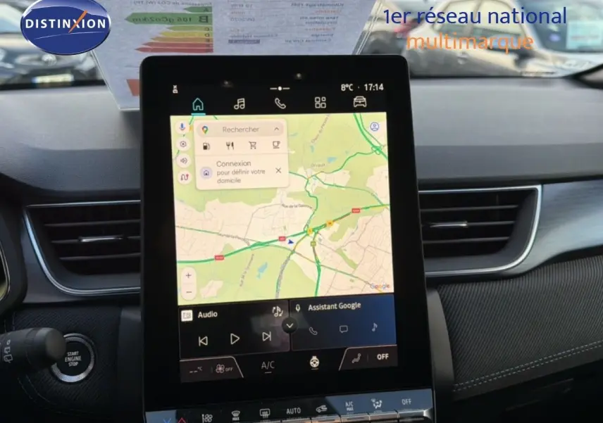 Vue intérieure centrée sur l'écran tactile du tableau de bord du Renault Captur blanc nacré avec toit gris, affichant la navigation.