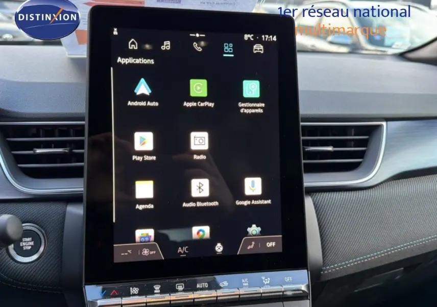 Vue intérieure centrée sur l'écran tactile du tableau de bord du Renault Captur blanc nacré 2025 avec toit gris.