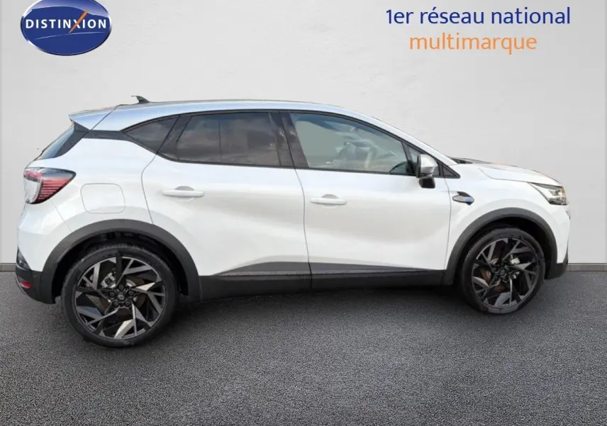 Profil côté gauche du Renault Captur blanc nacré avec toit gris, roues noires et jantes stylisées, sur fond neutre.