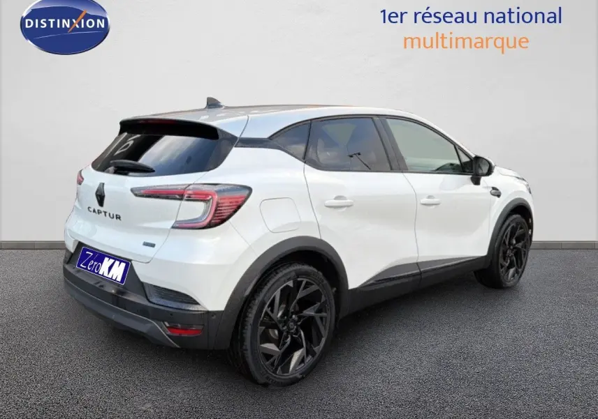 Vue 3/4 arrière droite du Renault Captur blanc nacré avec toit gris et jantes noires distinctives.
