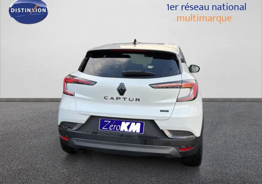 Vue arrière d'un Renault Captur blanc nacré avec toit gris, modèle hybride 2025, sur fond neutre.