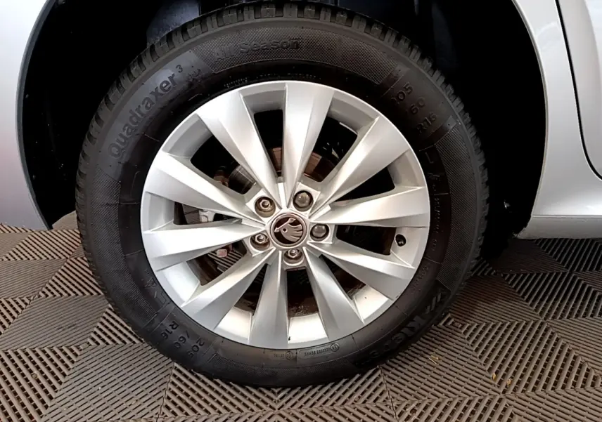 Gros plan sur la roue avant gauche gris clair d'un Skoda Kamiq 2022 avec jante alliage et logo central visible.