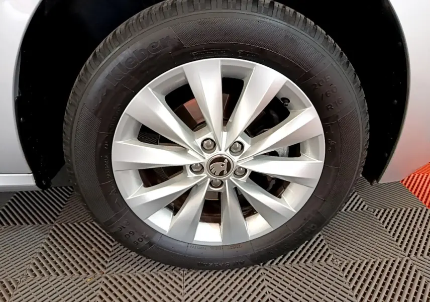 Gros plan sur la roue avant droite gris clair d'un Skoda Kamiq 2022 avec jante alliage et logo central visible.