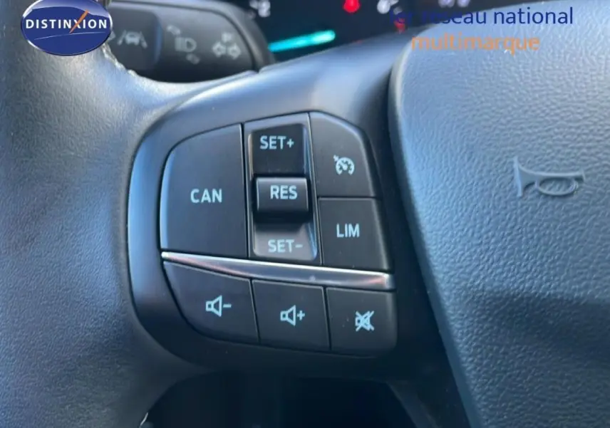 Gros plan sur les commandes du régulateur de vitesse au volant d’une Ford Fiesta blanche de 2020.