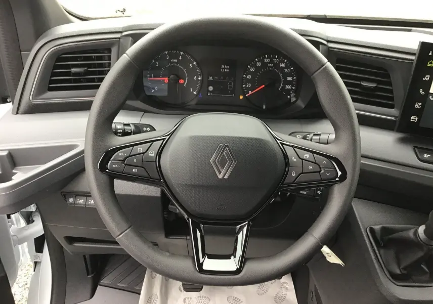 Vue intérieure centrée sur le volant noir du Renault Master 2025 avec tableau de bord et commandes visibles.