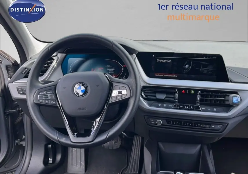 Vue intérieure frontale du tableau de bord et volant cuir noir d'une BMW Série 1 116i 2022 en Frozen Pure Grey.