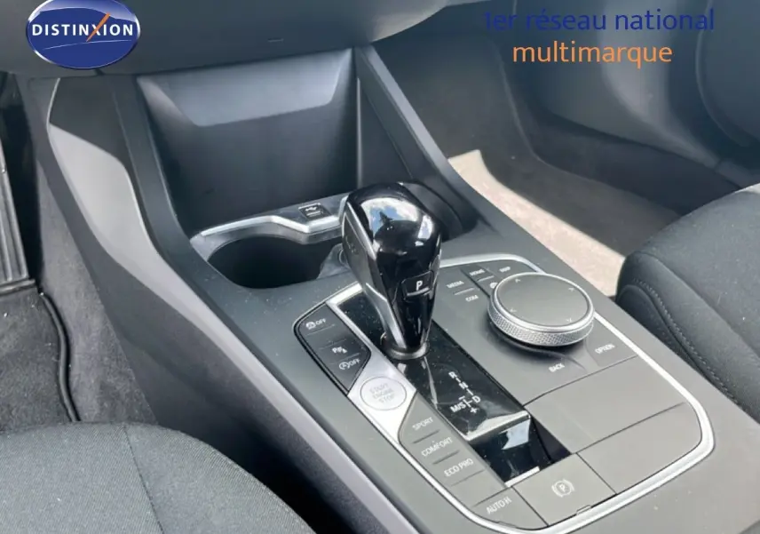 Vue rapprochée de la console centrale de la BMW Série 1 116i 2022, avec levier de vitesse automatique noir brillant.
