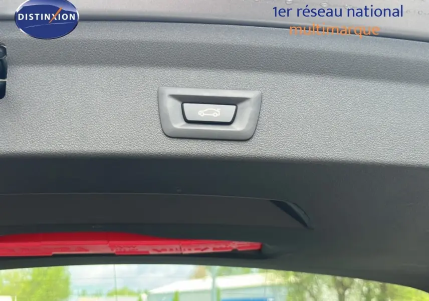 Bouton d'ouverture du coffre sur la garniture intérieure arrière d'une BMW Série 1 116i 2022 couleur Frozen Pure Grey.