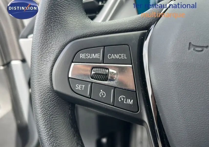 Gros plan sur les commandes de régulateur de vitesse au volant cuir noir d'une BMW Série 1 116i 2022.