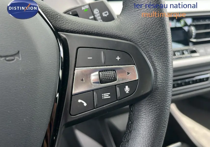 Gros plan sur la partie droite du volant en cuir noir de la BMW Série 1 116i 2022, avec commandes intégrées.