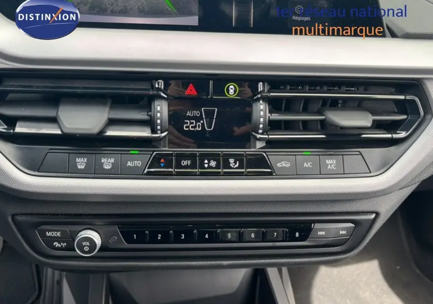 Vue rapprochée du tableau de bord de la BMW Série 1 116i 2022 en gris Frozen Pure, montrant la console de climatisation et les commandes multimédia.