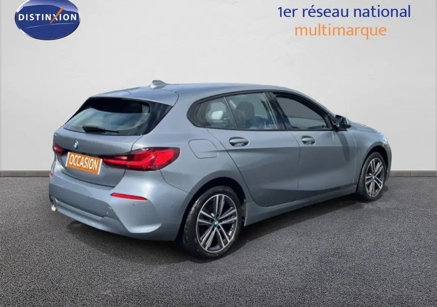 BMW Série 1 116i gris Frozen Pure vue 3/4 arrière droit, avec feux arrière LED et jantes bi-ton 17 pouces.