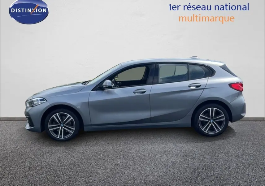 Profil gauche d'une BMW Série 1 116i 2022 en gris Frozen Pure avec jantes alliage bi-ton et vitres teintées.