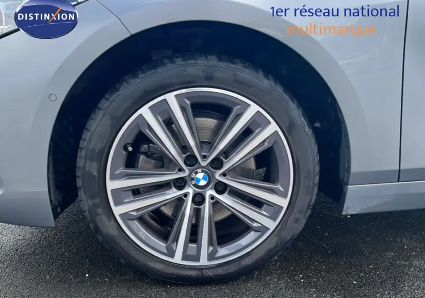 Gros plan sur la roue avant droite d'une BMW Série 1 116i 2022 en Frozen Pure Grey avec jante alliage bi-ton.