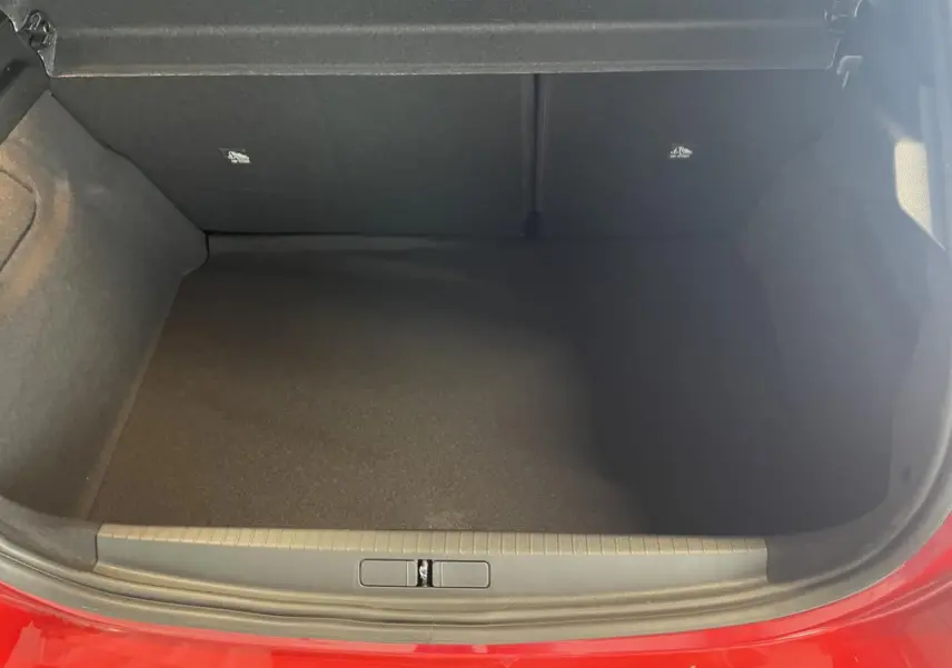 Coffre ouvert vu de face d’une Opel Corsa rouge 2026, montrant l’espace de chargement vide et bordure de coffre.