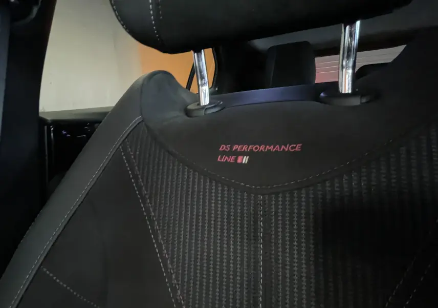 Gros plan sur l'appui-tête avant avec broderie "DS Performance Line" sur sellerie tissu tressé Basalte et Alcantara noir.