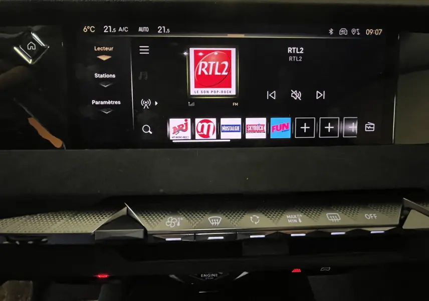 Écran tactile central du tableau de bord du DS4 2024 affichant les stations radio avec commandes climatisation en dessous.