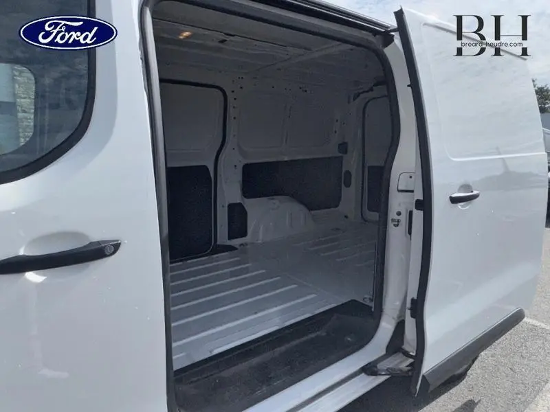 Vue latérale droite du fourgon Peugeot Expert Long blanc Banquise avec porte coulissante ouverte montrant l'espace de chargement vide