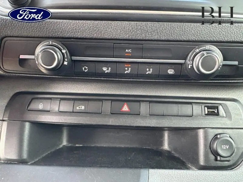 Tableau de bord noir du Peugeot Expert Fourgon blanc, vue rapprochée des commandes climatisation et boutons centraux.