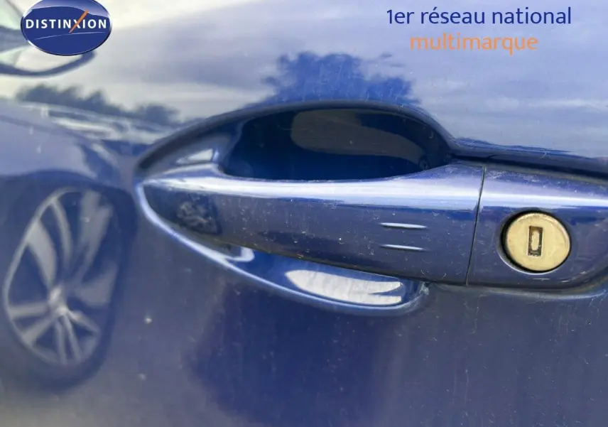 Poignée de porte côté gauche bleu Magnetic d'une Peugeot 308 2020 avec serrure visible et reflet de roue.