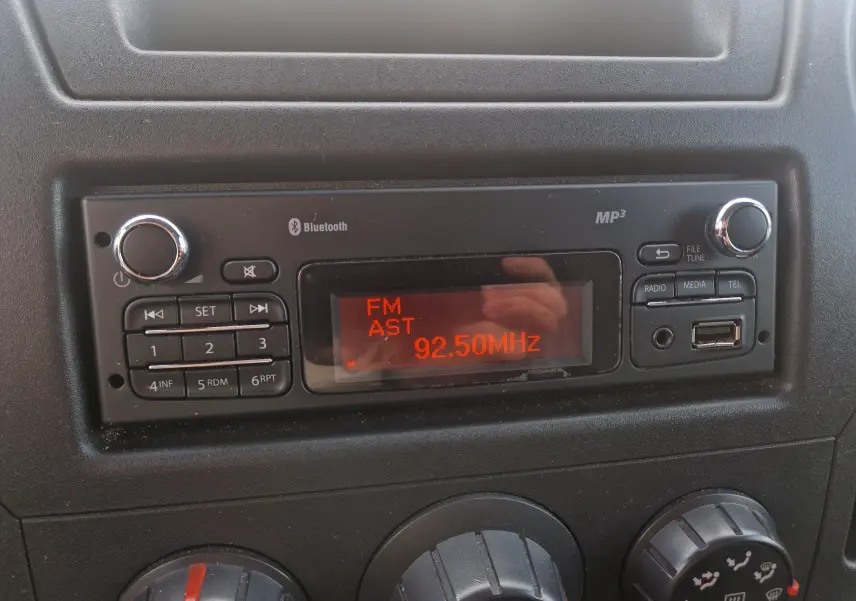 Gros plan sur la radio Bluetooth MP3 affichant la fréquence 92.50 MHz dans le tableau de bord noir du Renault Master Plancher Cabine blanc.