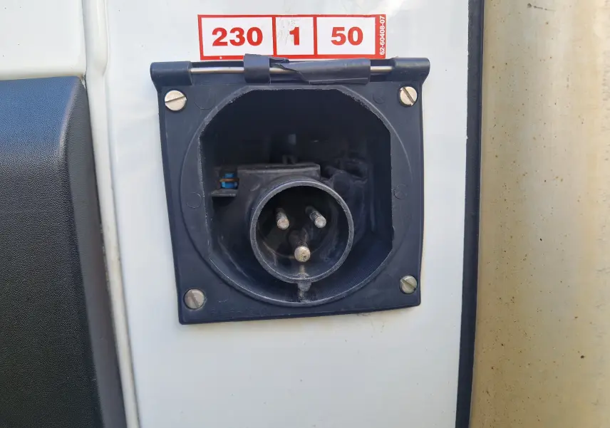 Prise électrique 230V en gros plan sur la carrosserie blanche du Renault Master Plancher Cabine version frigo.