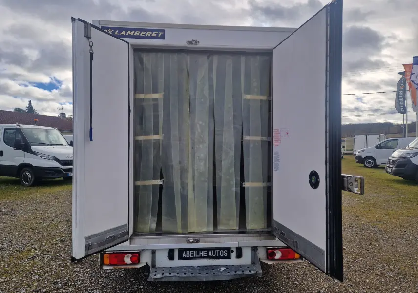 Vue arrière du Renault Master Plancher Cabine blanc avec portes frigorifiques ouvertes et rideaux plastiques transparents visibles.