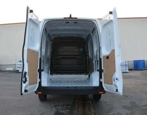 Vue arrière d’un Renault Master blanc 2025 avec portes arrière ouvertes montrant l’espace de chargement vide et la cloison pleine.