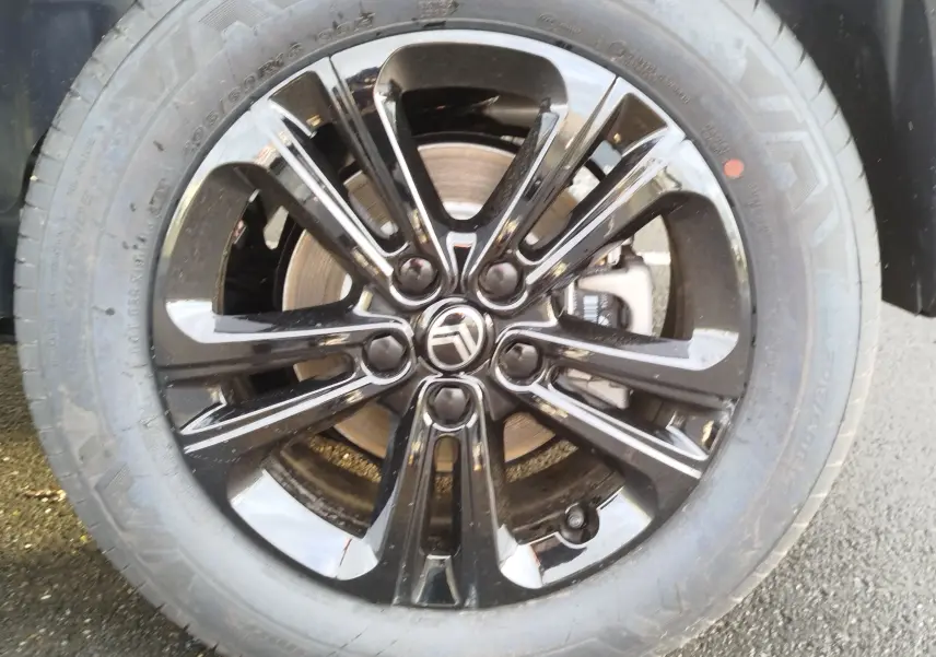 Gros plan sur la jante noire brillante d'une Citroën Berlingo 2026, mettant en valeur le logo central et le disque de frein.