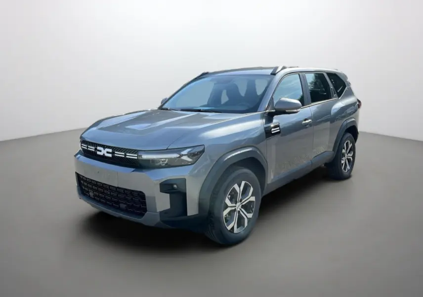 Vue 3/4 avant du Dacia Bigster Hybrid 155 Expression Plus en gris schiste avec jantes alu et barres de toit visibles.