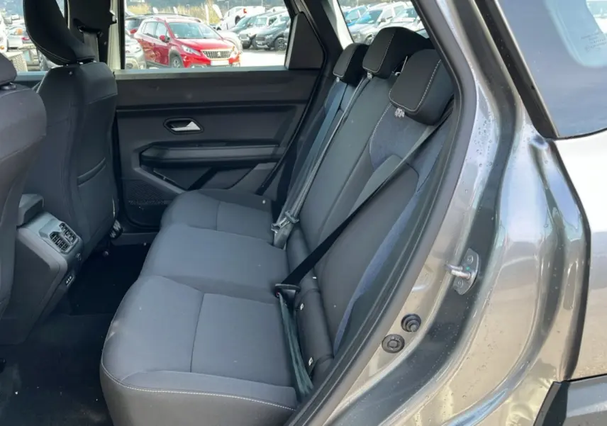 Vue côté droit de l’intérieur arrière du Dacia Bigster gris schiste, montrant la banquette trois places avec ceintures de sécurité.
