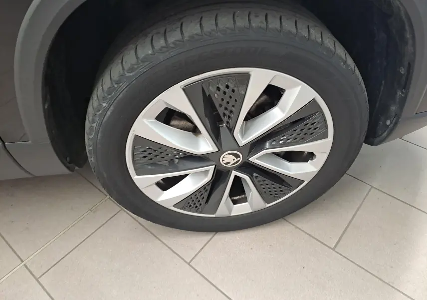 Gros plan sur la roue avant gauche du Skoda Karoq noir Magic Nacré avec jante alliage au design moderne.