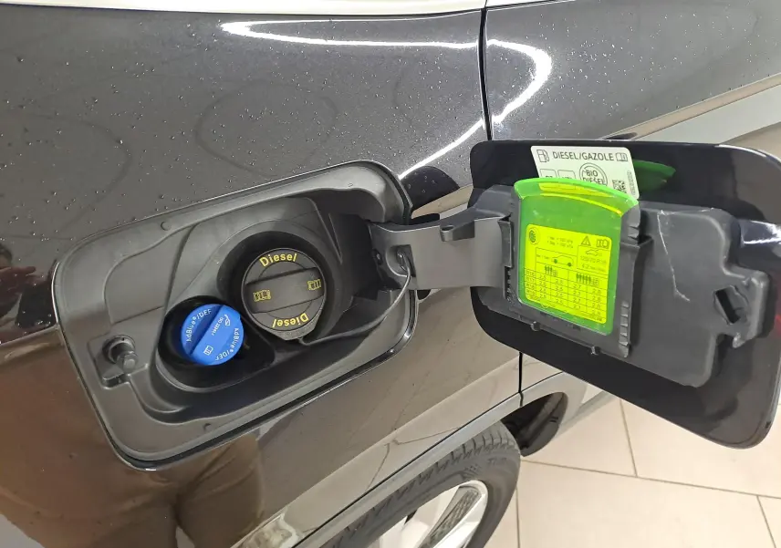 Vue rapprochée de la trappe à carburant côté gauche d’un Skoda Karoq noir Magic Nacré avec bouchons Diesel et AdBlue visibles.