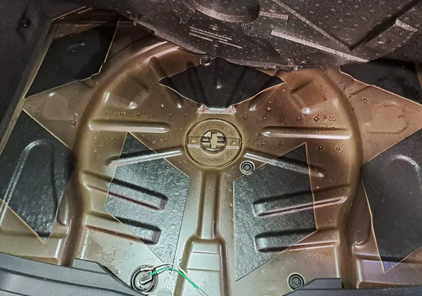 Vue du coffre du Skoda Karoq 2023 noir Magic Nacré, montrant l’espace de rangement sous le plancher sans roue de secours.