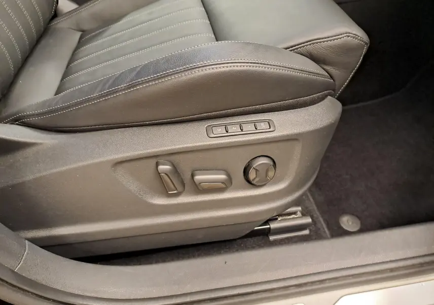 Gros plan sur les commandes de réglage électrique du siège en cuir noir du Skoda Karoq 2023 côté gauche.