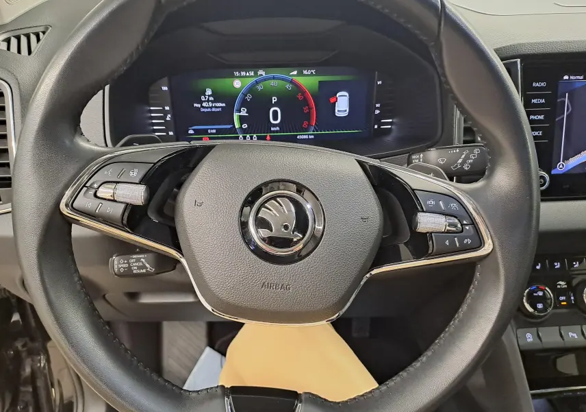 Vue rapprochée du volant cuir noir du Skoda Karoq 2023 avec tableau de bord numérique et commandes intégrées.