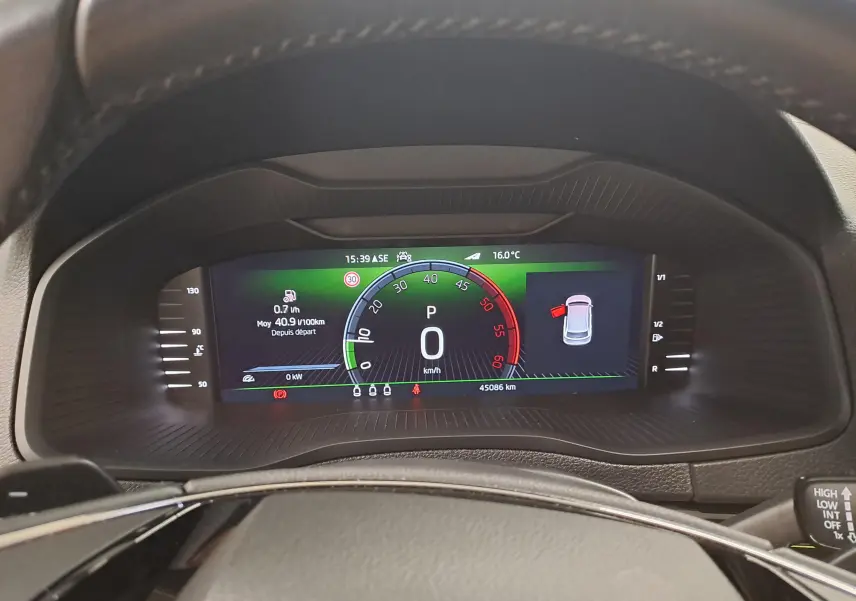 Vue rapprochée du tableau de bord numérique du Skoda Karoq noir Magic Nacré, affichant la vitesse et les alertes.